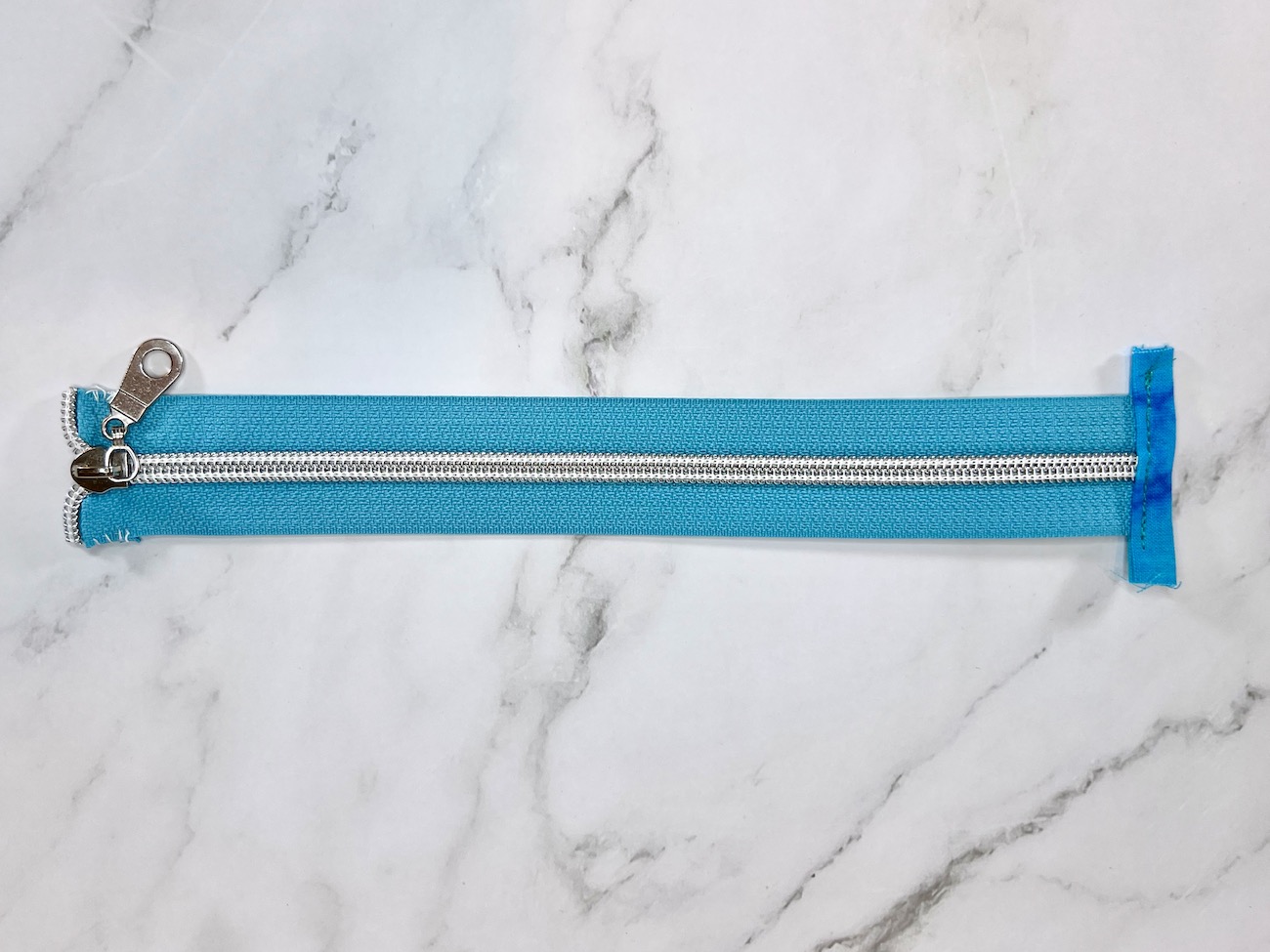 Zipper tape with zipper tab attached