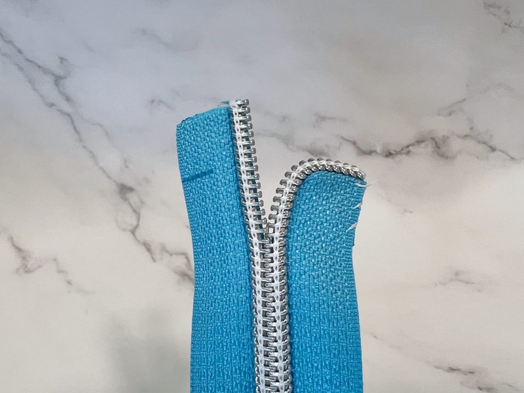 One side of the zipper tape curved and basted from the front