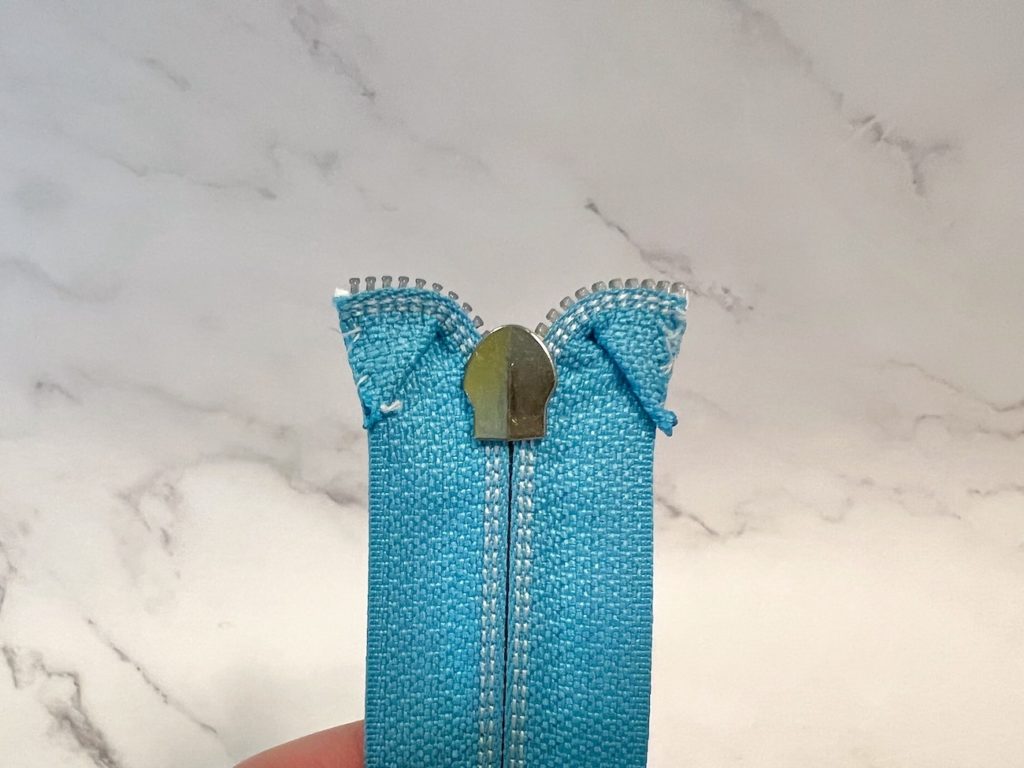 Both sides of the zipper tape are curved and basted from the back