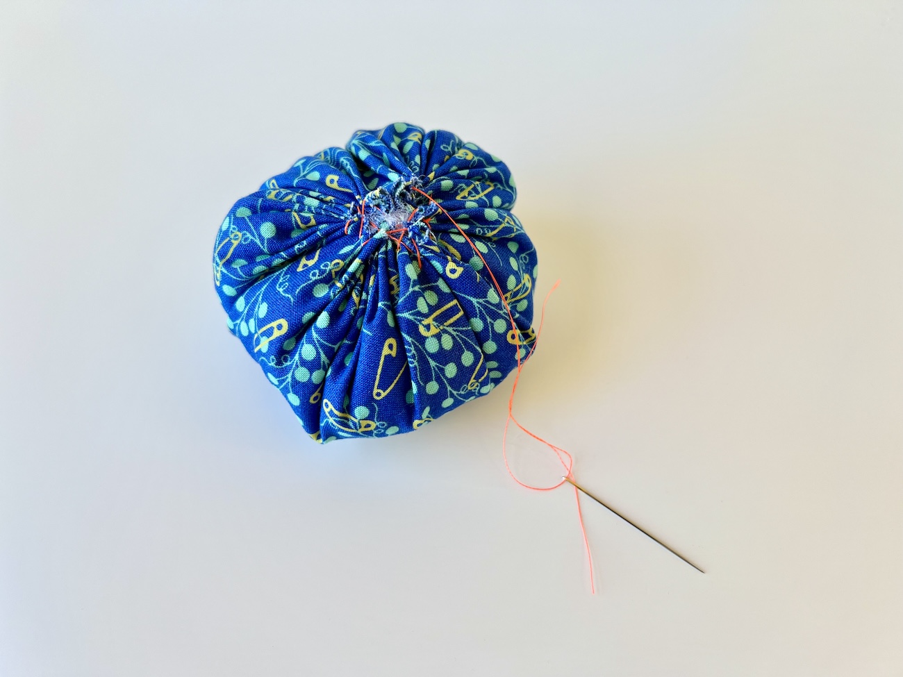 A gathered closed circle of fabric stuffed with fiber fill