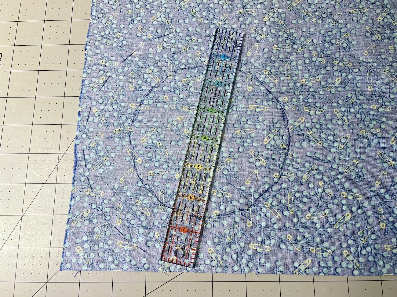 A ruler being used to mark a dashed circle one and a half inches larger then the traced circle